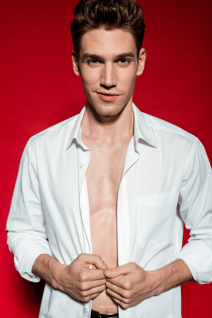 sexy giovane uomo elegante in camicia sbottonata su sfondo rosso
 - Foto, immagini