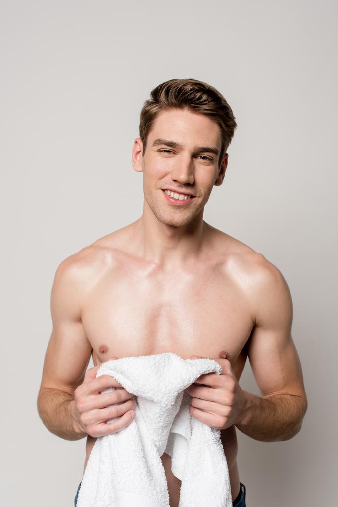sorriso sexy giovane uomo nudo in possesso di asciugamano di cotone isolato su grigio
 - Foto, immagini