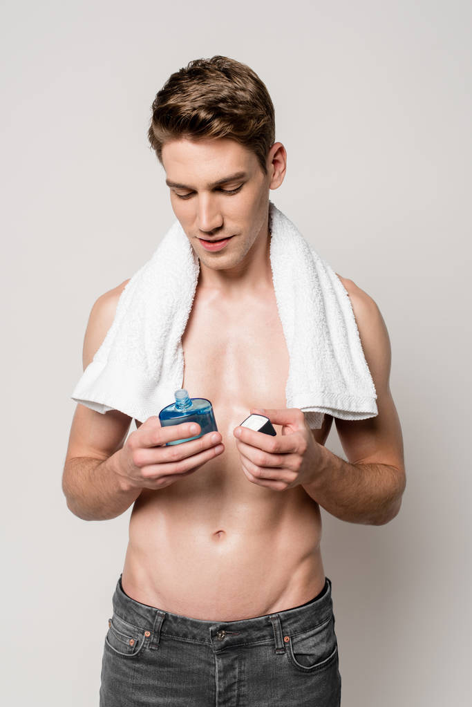 homme sexy avec torse musculaire avec lotion après rasage et serviette isolée sur gris
 - Photo, image