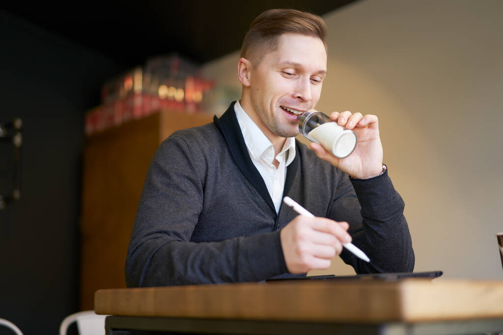 Αρσενικό με τη ζάχαρη μπολ στα χέρια του κάθεται στο τραπέζι - Φωτογραφία, εικόνα