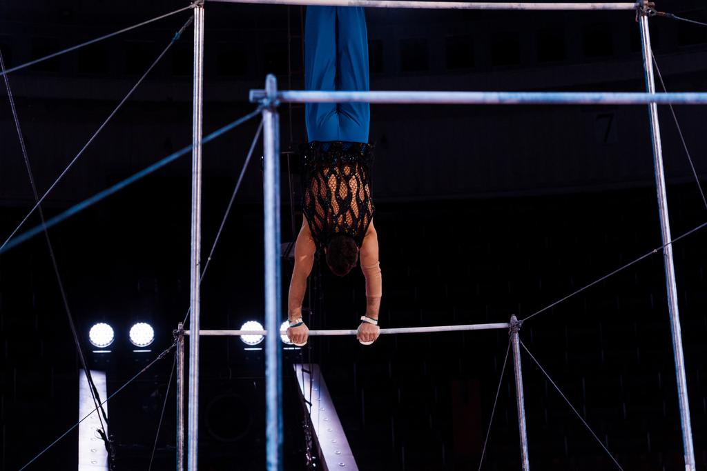 Sirk arenasındaki yatay barlarda gösteri yapan atletik jimnastikçilerin arka görüntüsü   - Fotoğraf, Görsel