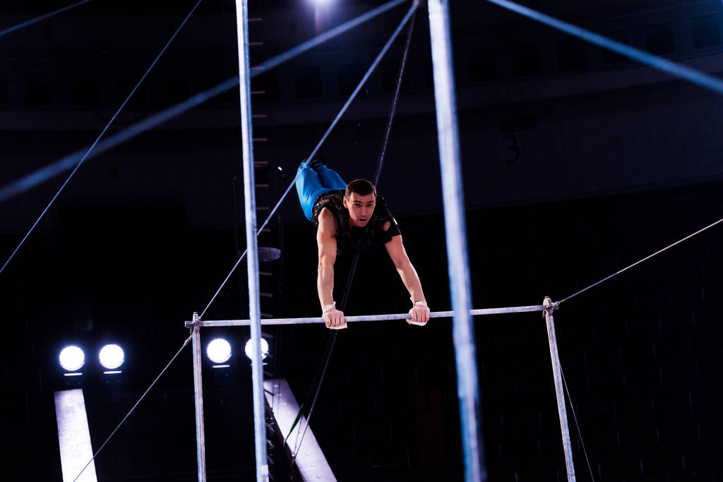 szelektív fókusz atlétikai tornász teljesítő horizontális bárok arénában cirkusz   - Fotó, kép