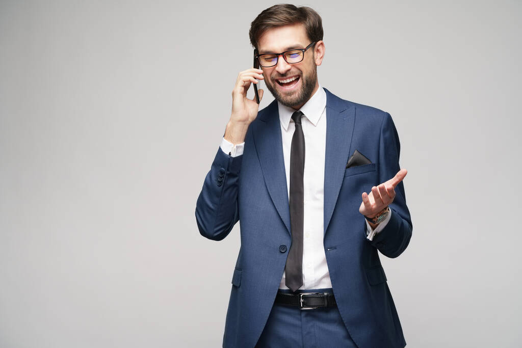 businessman talking on the phone isolated over grey background - Photo, Image