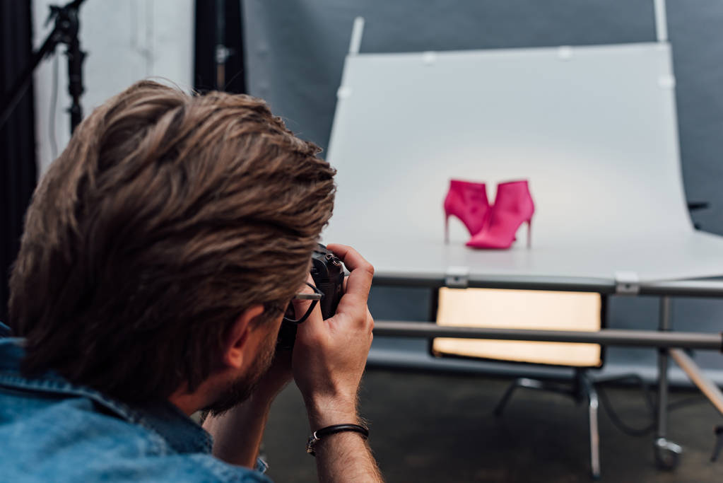 selective focus of photographer taking photo of pink shoes  - Photo, Image