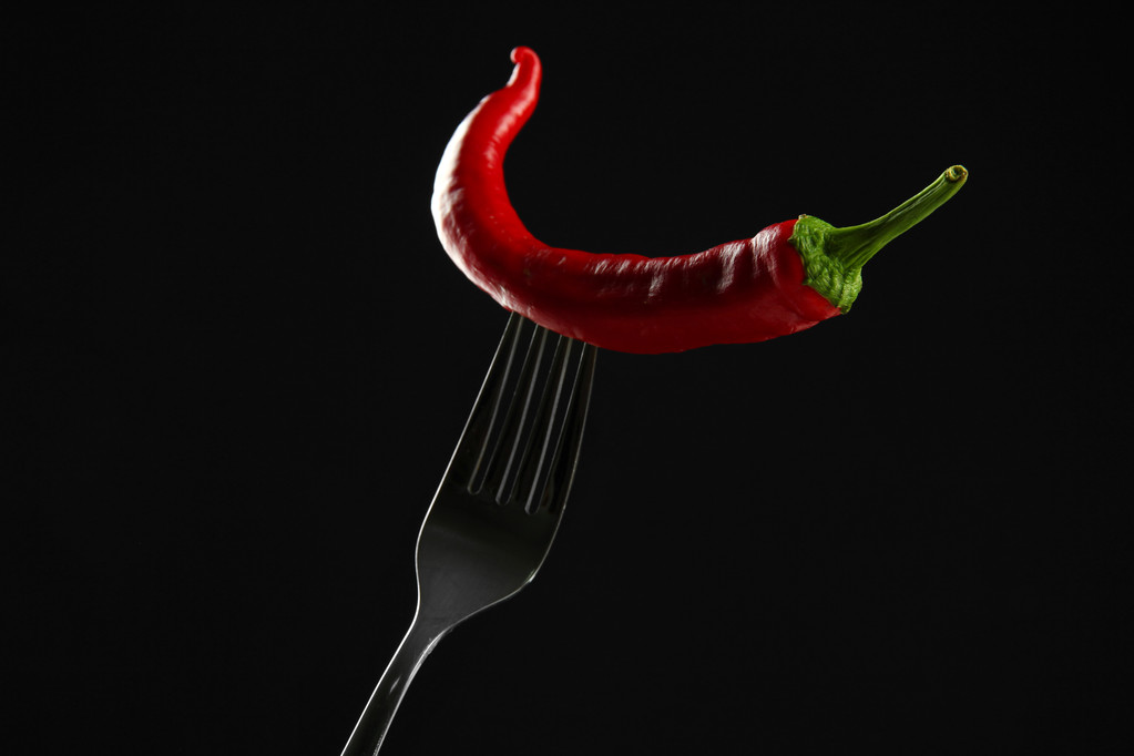 Pimienta picante roja en tenedor, aislada en negro
 - Foto, Imagen