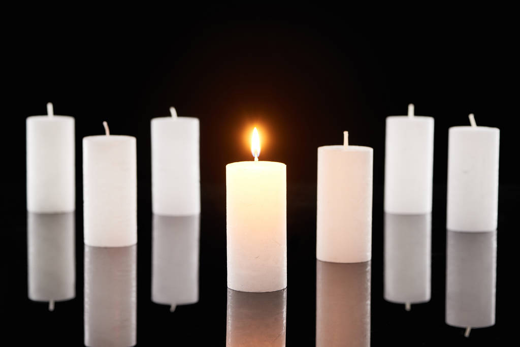foyer sélectif des bougies blanches allumées près d'un autre isolé sur noir
 - Photo, image