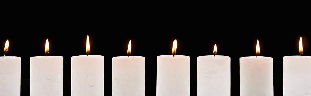 hořící bílé svíčky zářící v řadě izolované na černém, panoramatickém záběru - Fotografie, Obrázek