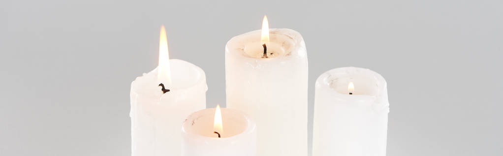 λευκά αναμμένα κεριά που λάμπουν απομονωμένα σε γκρι, πανοραμική λήψη - Φωτογραφία, εικόνα