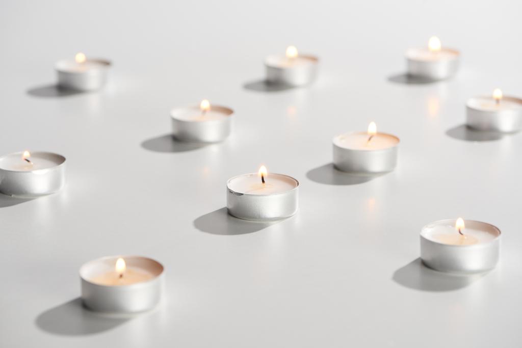 επιλεκτική εστίαση της καύσης κεριών που λάμπουν στη λευκή επιφάνεια - Φωτογραφία, εικόνα