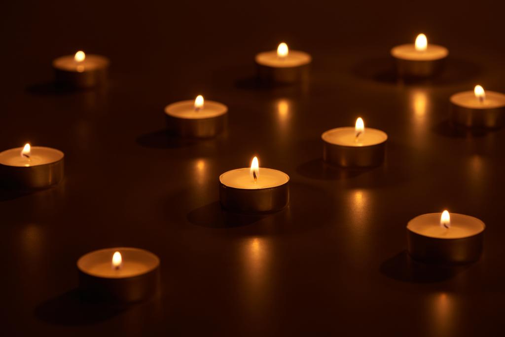 селективный фокус горящих белых свечей, светящихся в темноте
 - Фото, изображение