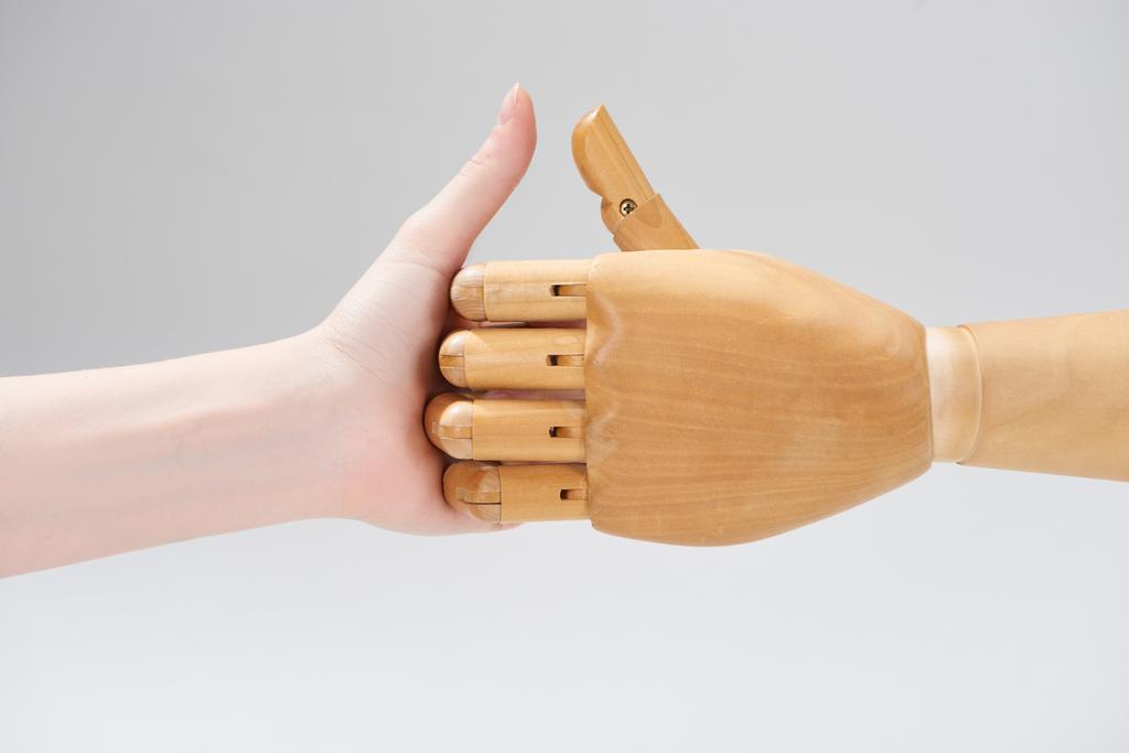 Καλλιεργημένη άποψη της γυναίκας που παίζει παιχνίδι δάχτυλο με ξύλινη κούκλα που απομονώνονται σε γκρι - Φωτογραφία, εικόνα