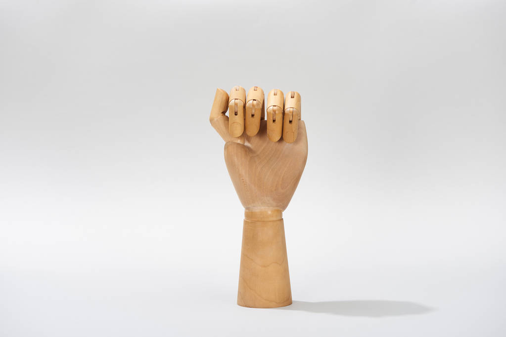 Рука деревянной куклы в кулаке на сером фоне
 - Фото, изображение