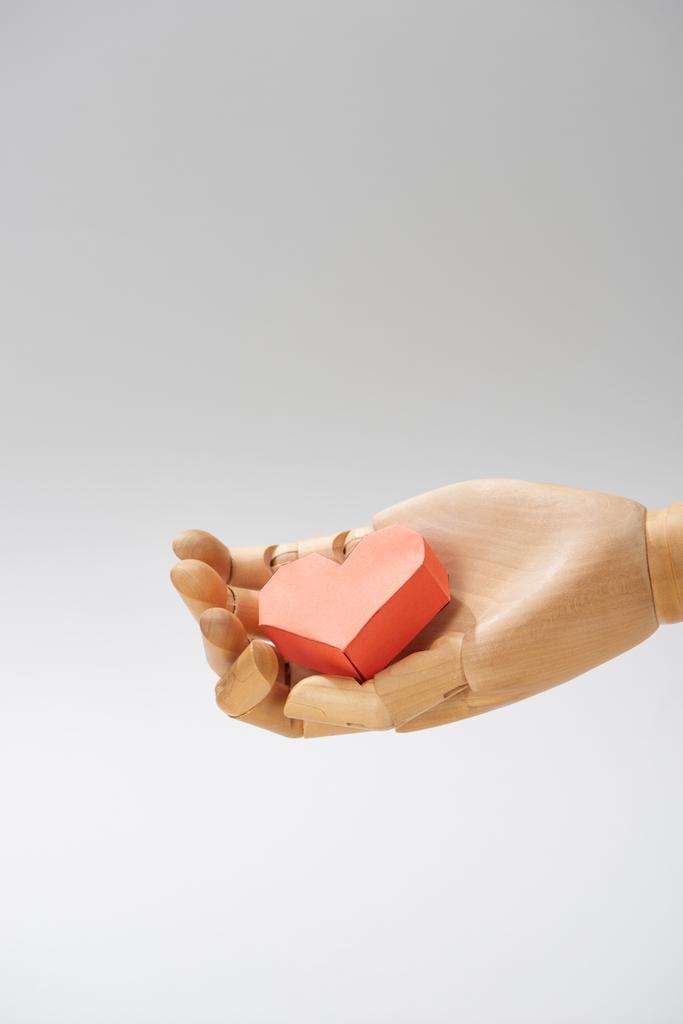 Srdce tvarovaný papír na dřevěné ruce panenky izolované na šedé - Fotografie, Obrázek
