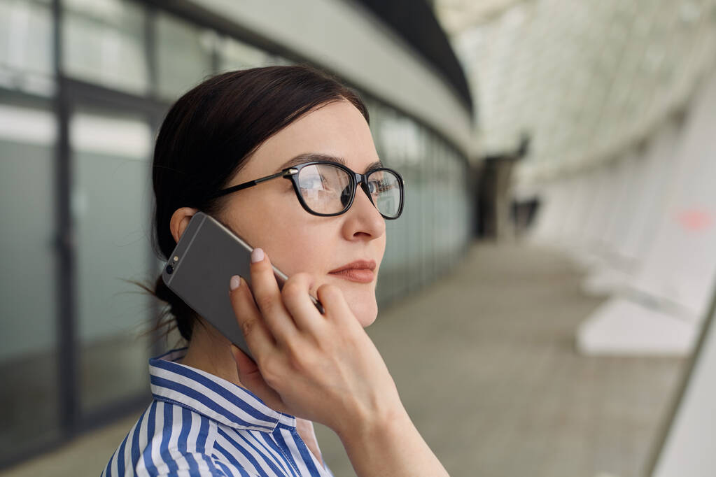 Занятая милая самоуверенная леди разговаривает на сером мобильном телефоне о бизнесе
 - Фото, изображение