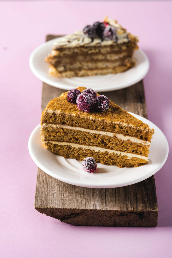 Due pezzi di torta casalinga gustosa su piatto bianco vassoio di legno rosa sfondo verticale fatto in casa Dessert
 - Foto, immagini
