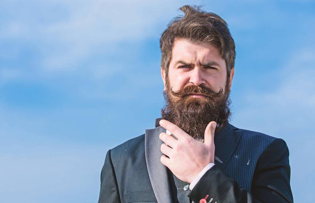 Facial hair beard and mustache care. Beard fashion trend. Invest in stylish appearance. Grow thick beard fast. Man bearded hipster wear formal suit blue sky background. Vintage style long beard - Photo, Image