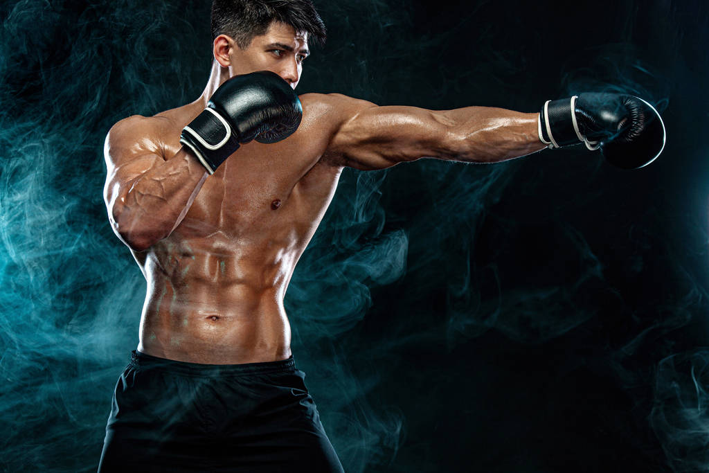 Koncept fitness a boxu. Boxer, muž bojující nebo pózující v rukavicích na černém pozadí. Individuální sportovní rekreace. - Fotografie, Obrázek