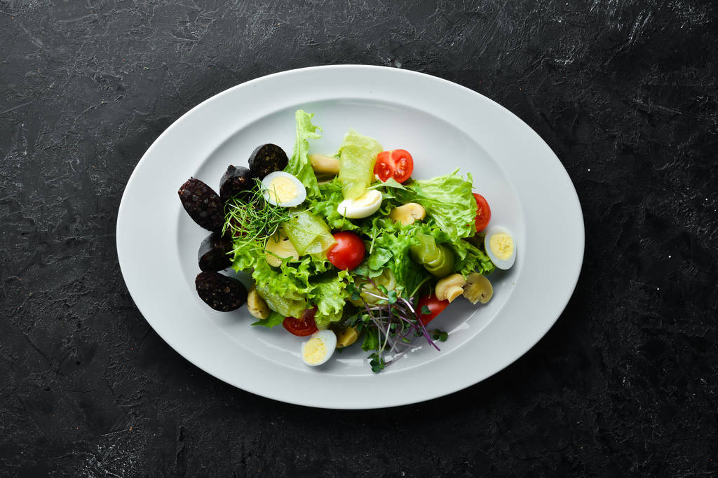 Salat mit Gemüse, Blutwurst und Pilzen auf einem Teller. Ansicht von oben. Freiraum für Ihren Text. rustikaler Stil. - Foto, Bild