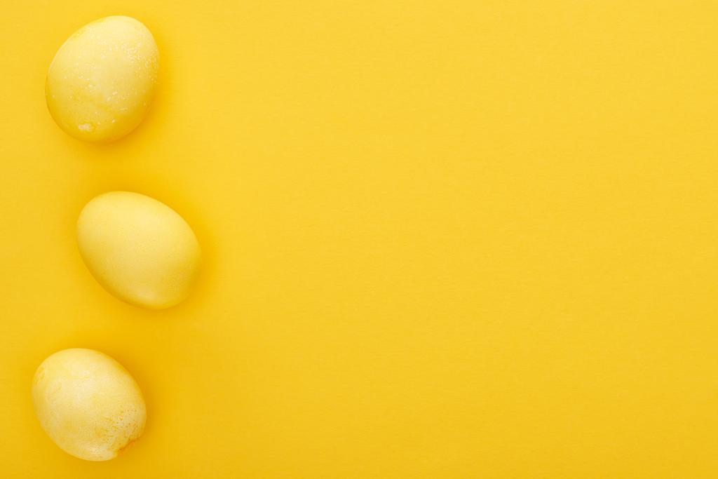 vista superior de huevos de Pascua pintados sobre fondo amarillo colorido
 - Foto, imagen