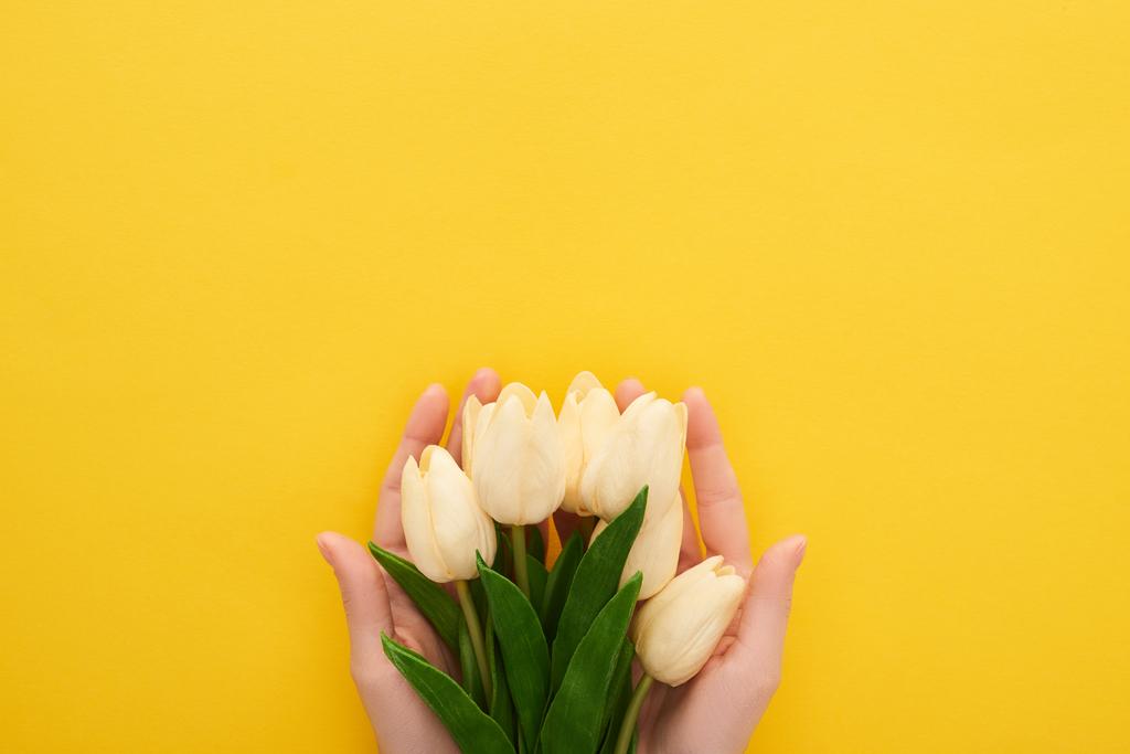 kivágott kilátás nő gazdaság tavasz tulipán színes sárga háttér - Fotó, kép