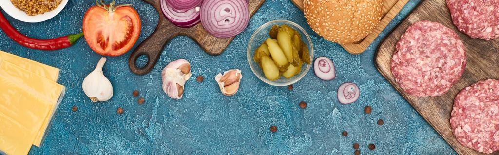 Mavi desenli yüzeydeki taze hamburgerlerin üst görüntüsü, panoramik çekim - Fotoğraf, Görsel