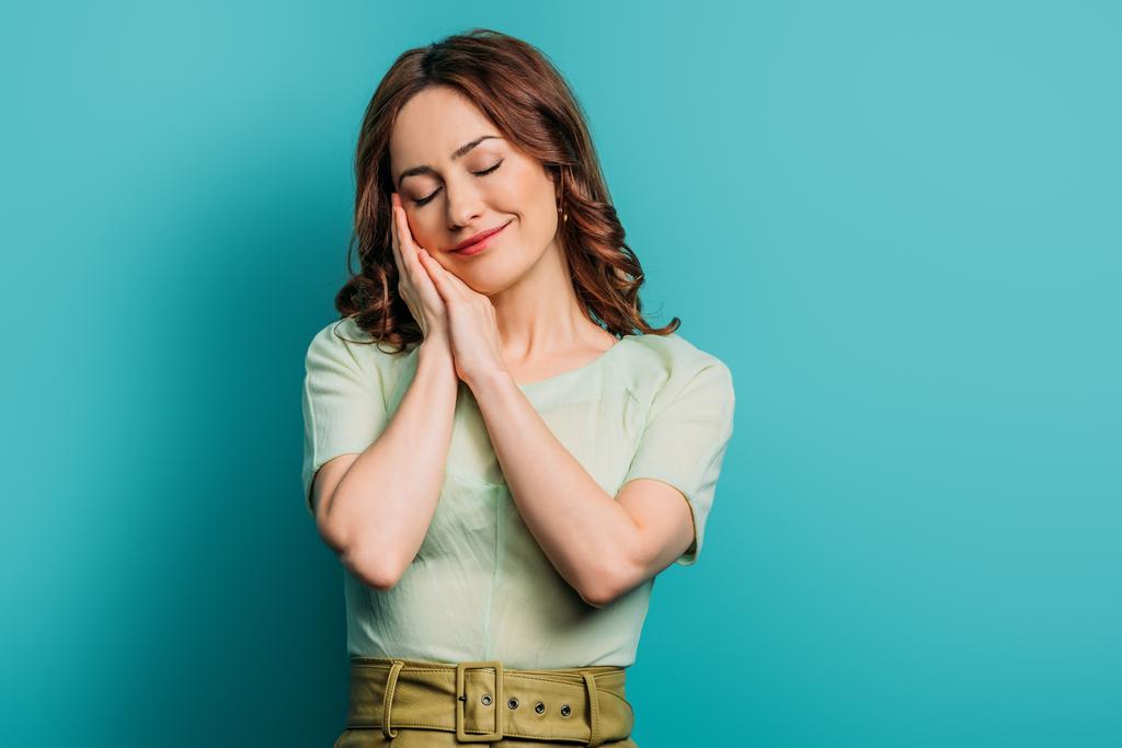 sleepy woman standing with closed eyes on blue background - Photo, Image