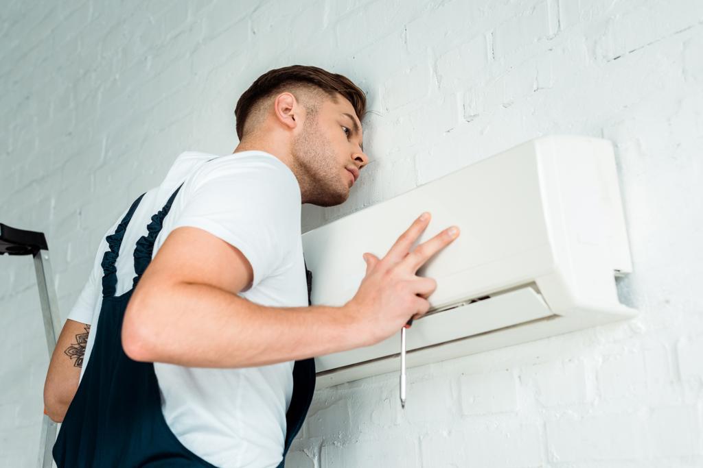 gutaussehender Arbeiter installiert Klimaanlage  - Foto, Bild