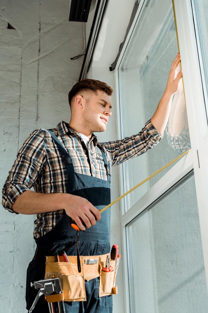 installer standing near windows and holding measuring tape - Photo, Image
