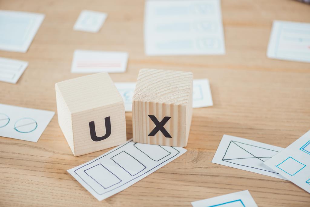 Selective focus of wooden cubes with ux letter and layouts on table - Photo, Image