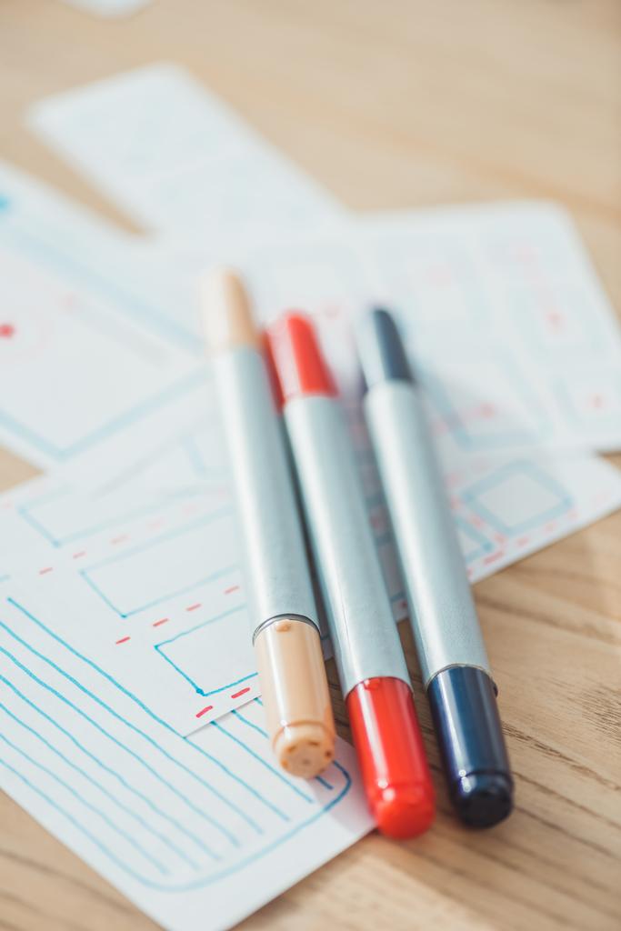 Selective focus of pens on ux sketch planning applications on wooden table - Photo, Image