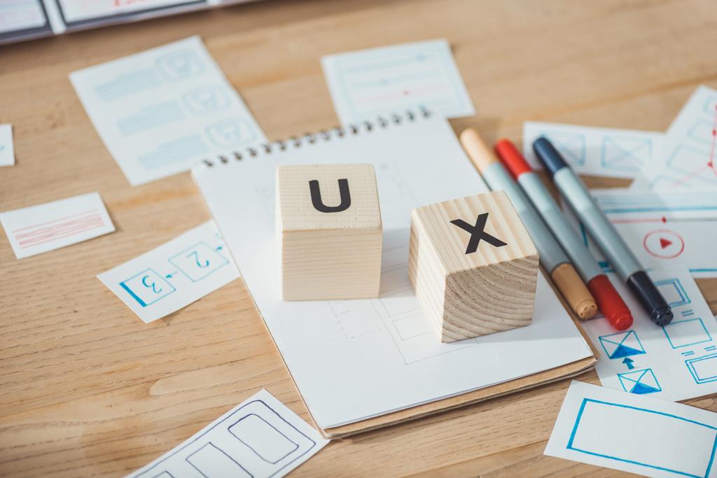 Selective focus of wooden cubes with ux letters and website template applications on wooden table - Photo, Image