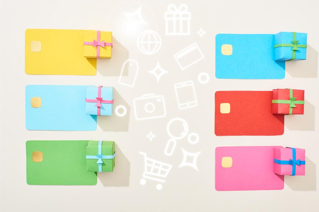 top view of multicolored empty credit cards and gift boxes on white background with icons illustration  - Fotoğraf, Görsel
