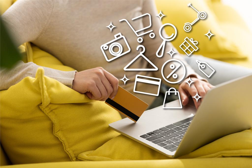 Cropped view of woman holding credit card and using laptop near illustration - Photo, Image