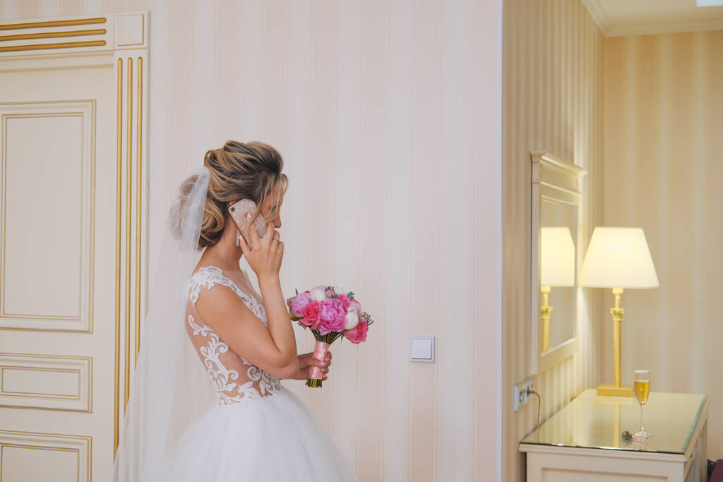 Молода наречена використовує смартфон у кімнаті
 - Фото, зображення