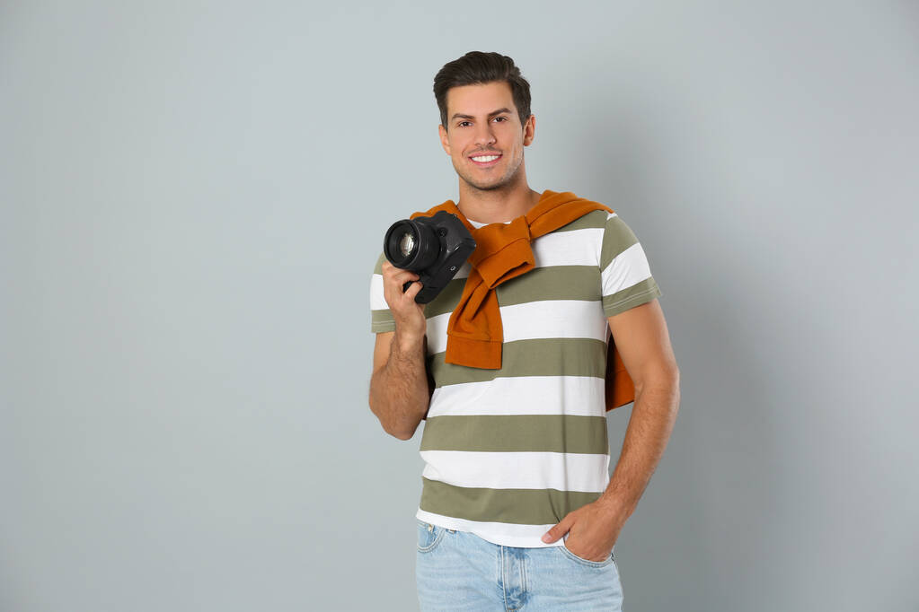 Ammattimainen valokuvaaja työskentelee vaaleanharmaalla taustalla st
 - Valokuva, kuva