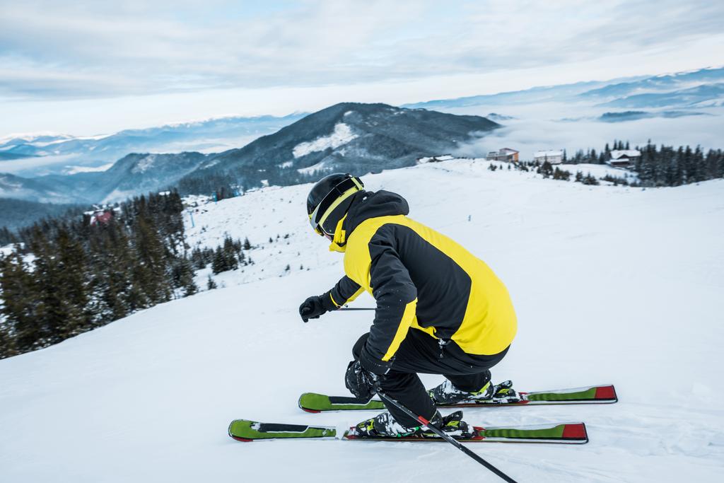sporter in helm skiën in de bergen - Foto, afbeelding
