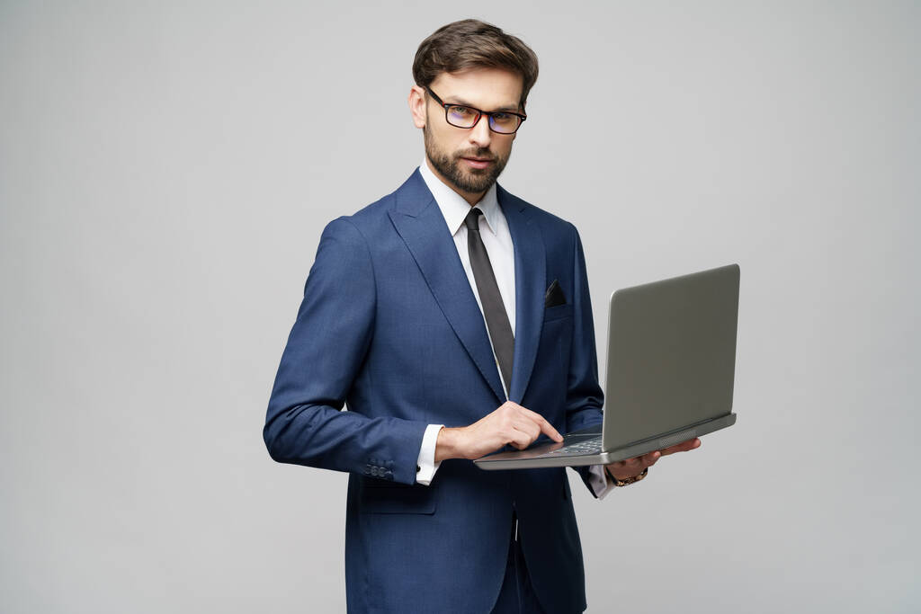 Νέος όμορφος επιχειρηματίας Κρατώντας ένα φορητό υπολογιστή με λευκή οθόνη - Φωτογραφία, εικόνα