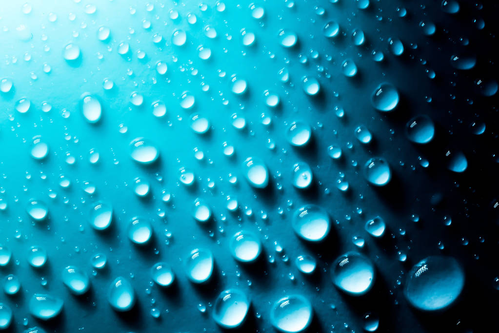 Gotas azules de macro agua en el material a la luz del sol
. - Foto, imagen