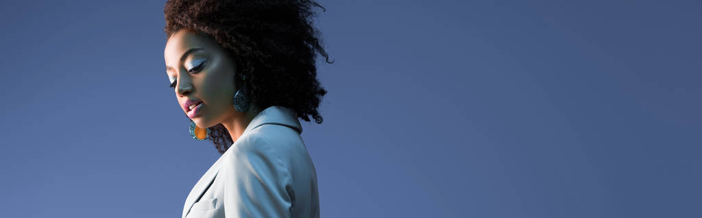  panoramaaufnahme der attraktiven afrikanisch-amerikanischen frau im anzug isoliert auf violett  - Foto, Bild