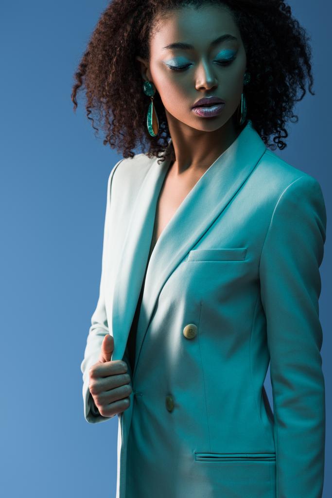 ελκυστική αφροαμερικανή γυναίκα με κοστούμι απομονωμένη στο μπλε  - Φωτογραφία, εικόνα