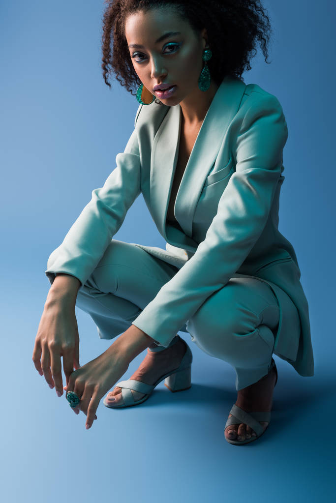 atractiva mujer afroamericana en traje elegante sobre fondo azul
  - Foto, imagen