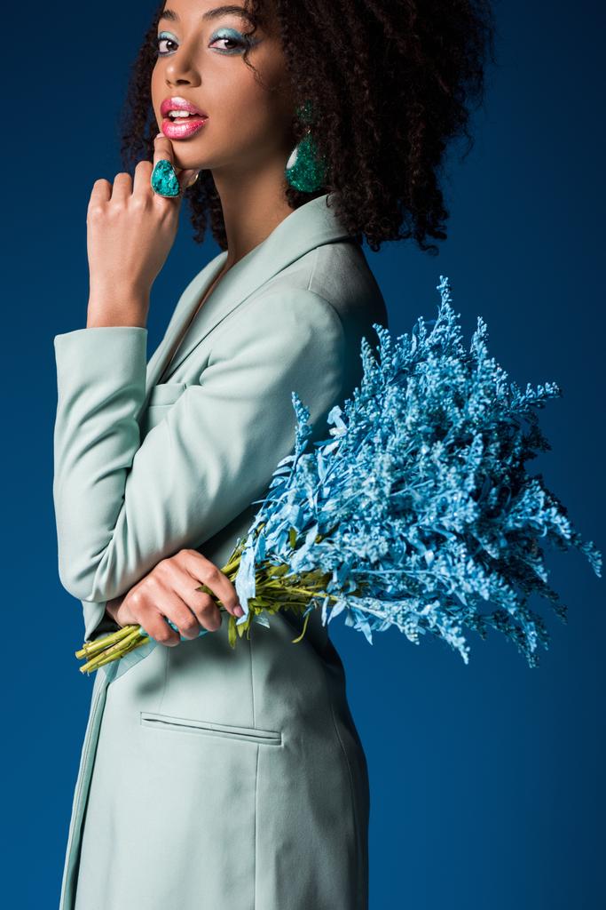 attraente donna afro-americana tenendo bouquet isolato su blu
 - Foto, immagini