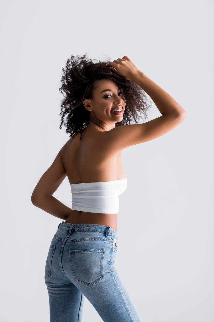 smiling african american woman in white top isolated on grey - Photo, Image