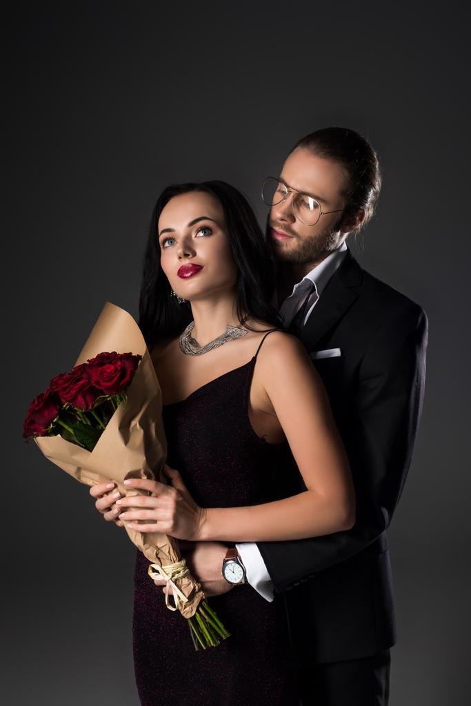 jeune couple tenant un bouquet de roses rouges le jour de la Saint-Valentin, isolé sur gris
 - Photo, image