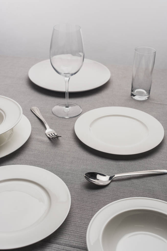 Обідній посуд з порожніми окулярами на сірій поверхні
 - Фото, зображення