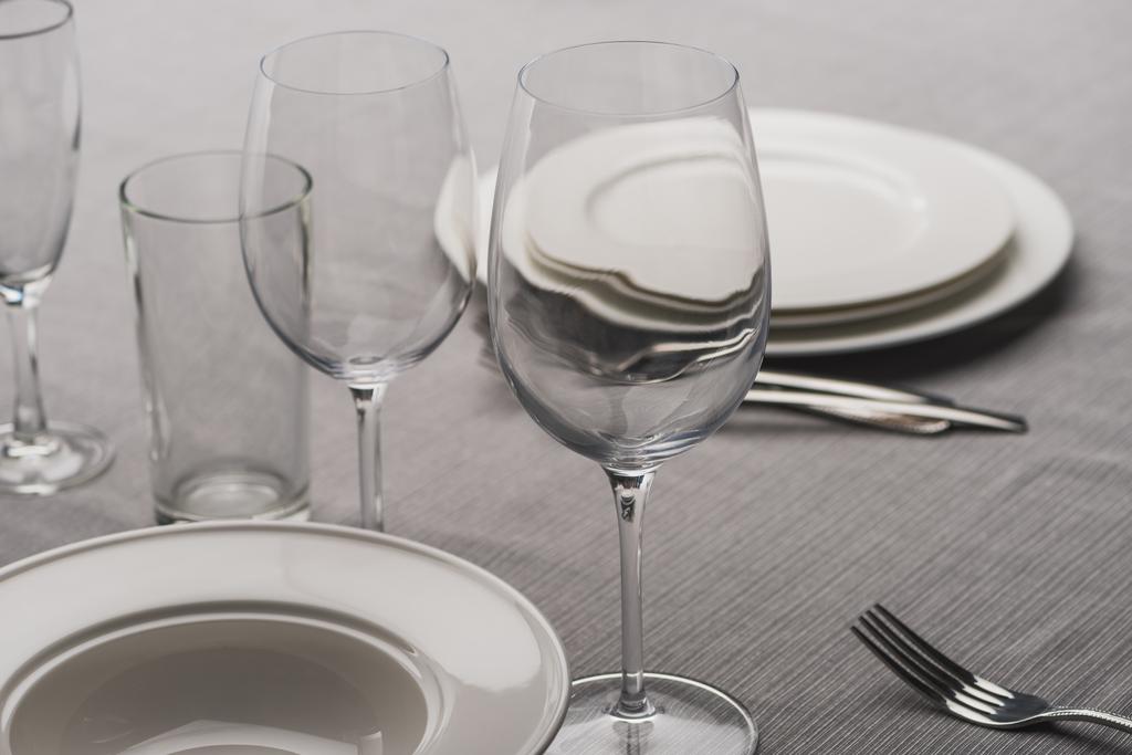Подача посуды в стаканах на серой скатерти
 - Фото, изображение