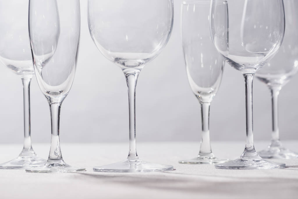 Shiny clear glasses on white surface isolated on grey - 写真・画像