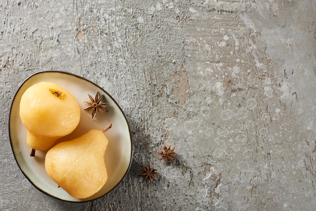 ylhäältä näkymä herkullinen päärynä viiniä tarjoillaan anis lautasella harmaalla betonipinnalla
 - Valokuva, kuva
