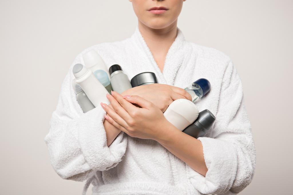 обрізаний вид жінки в халаті, що тримає різні дезодоранти ізольовані на сірому
 - Фото, зображення