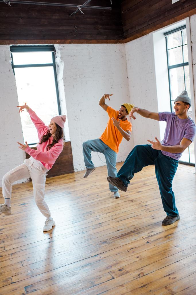 vonzó lány breakdance és gesztus elegáns multikulturális férfiak kalapban  - Fotó, kép